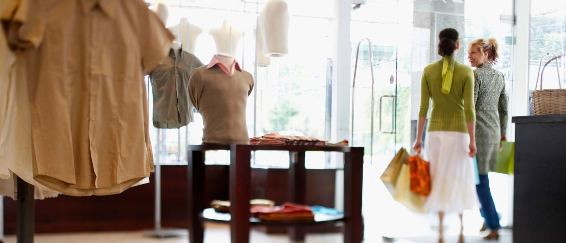 Mujeres con bolsas de compra saliendo de una tienda minorista