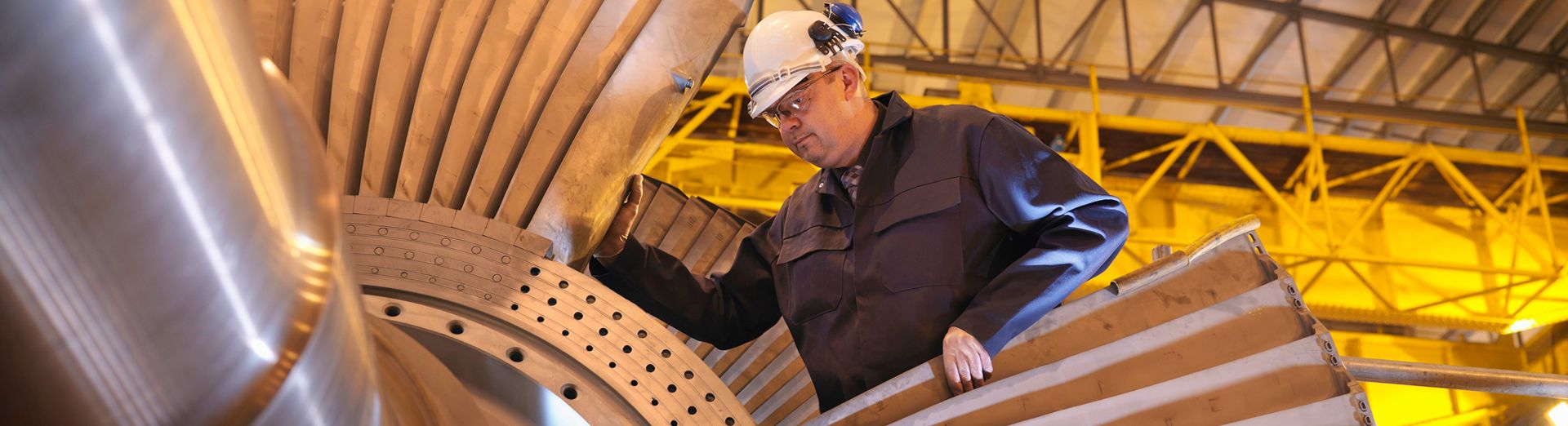 一名头戴安全帽的男士在操作一台大型机器，象征工业4.0技术的应用