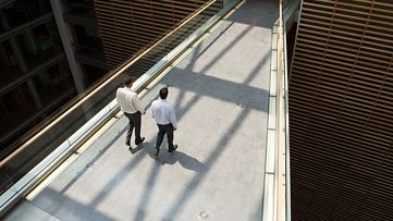 Two professionals in discussion on a bridge