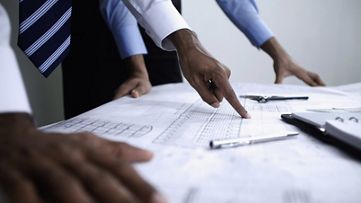 Businessmen reviewing planning features and data