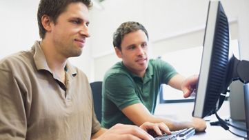 Two coworkers looking at computer screen