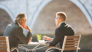 점심 식사를 하며 비즈니스에 대해 논의하는 두 명의 경영진