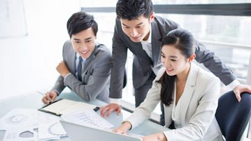 Employees reviewing and discussing information on a laptop