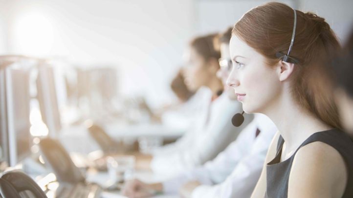 woman in the call center wearing headset and talking to customer