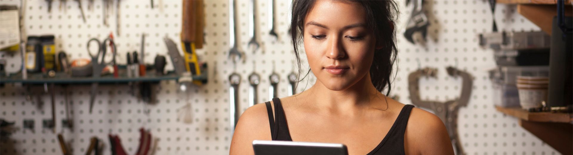 Mecánica mujer en un taller usando una tablet digital