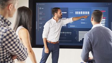 людина, що вказує на графіки на екрані