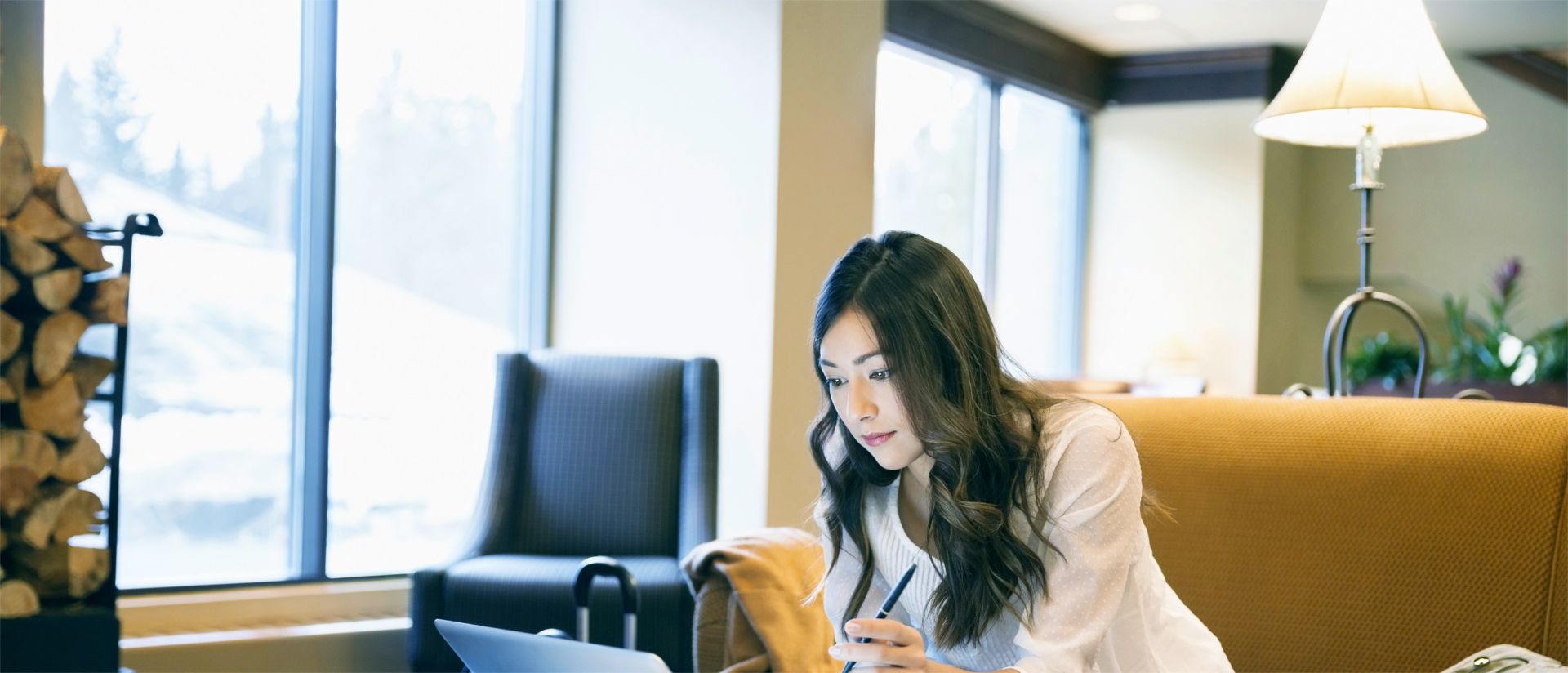写真：PCを使いロビーで製品プレゼンを行うアジア人女性セールス