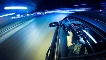 Rozmyty z powodu ruchu samochód jadący do przodu po drodze