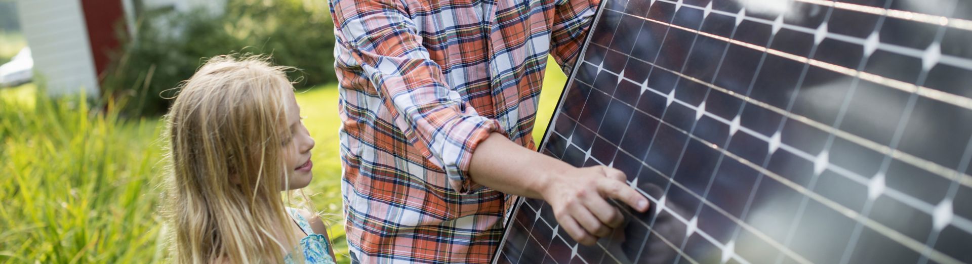 Image of a man and young girl looking at a solar panel