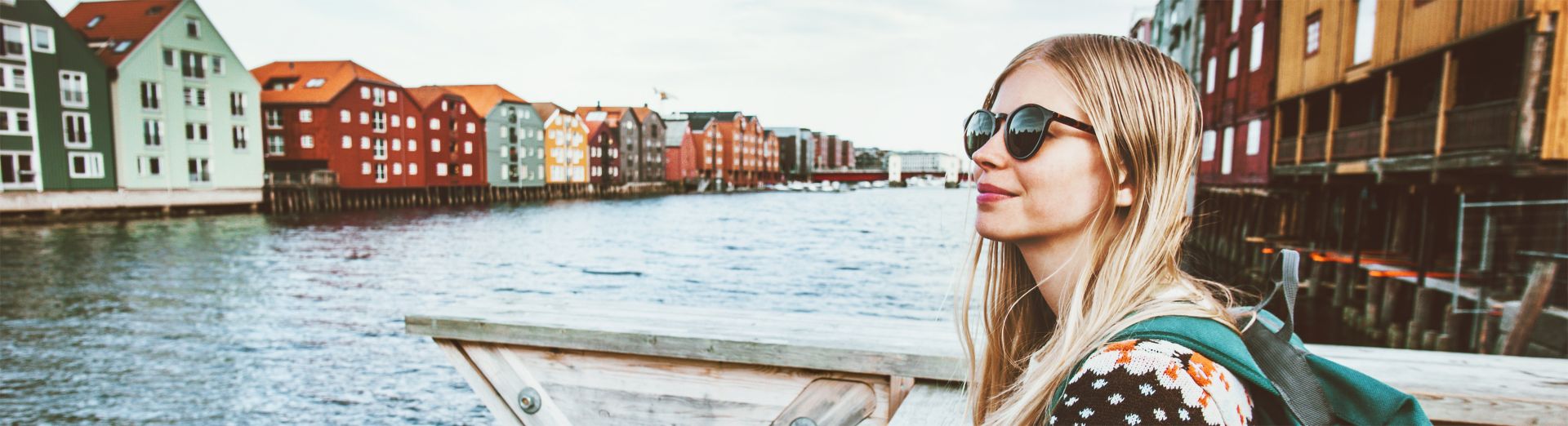 Young blonde woman on vacation in Norway sightseeing Scandinavian architecture