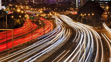 Australia Sydney city CBD with Harbour bridge at sunset with busy streets covered by cars at rush hour blurring headlights