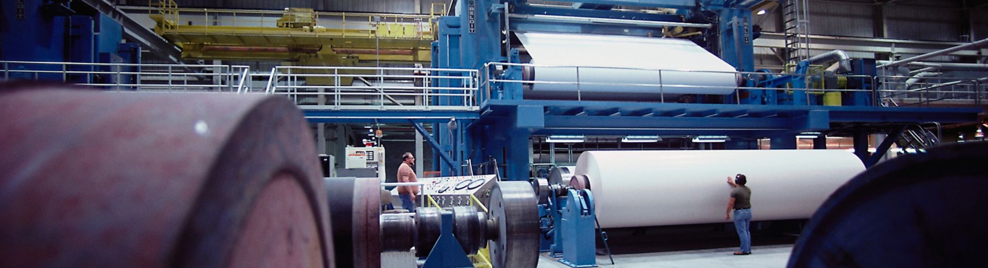 Technician observes paper production at a modern paper mill 