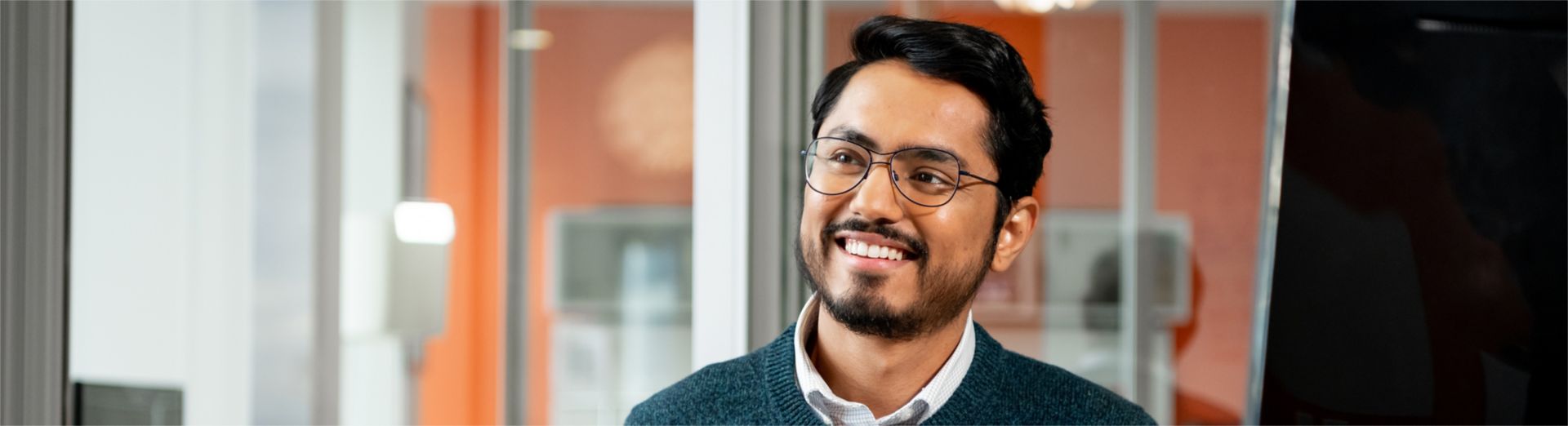 Hombre sonriente sentado en un escritorio