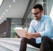  Portrait of businessman in glasses holding tablet