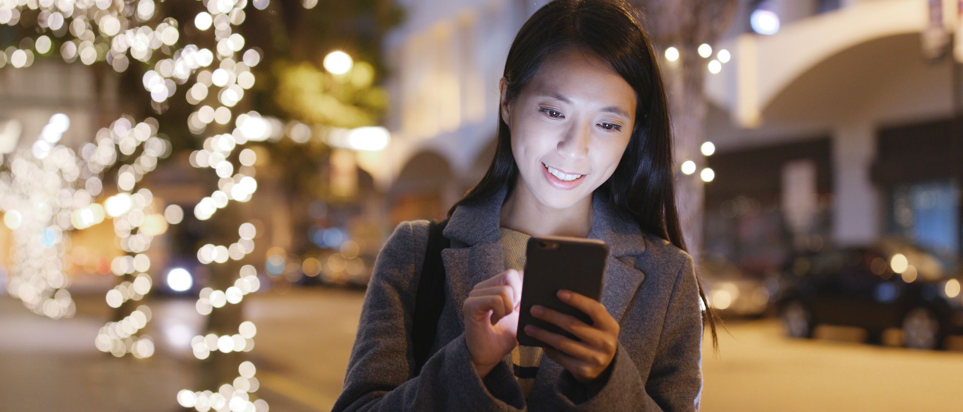 一位年轻的亚洲女性在手机上寻找SAP的工作机会