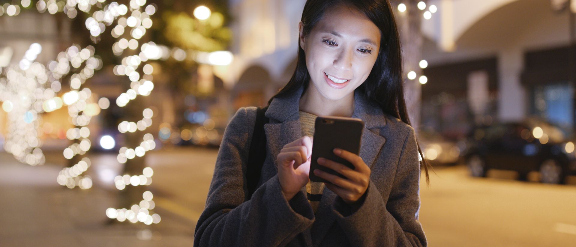 Image of a woman walking in the city using her cellphone