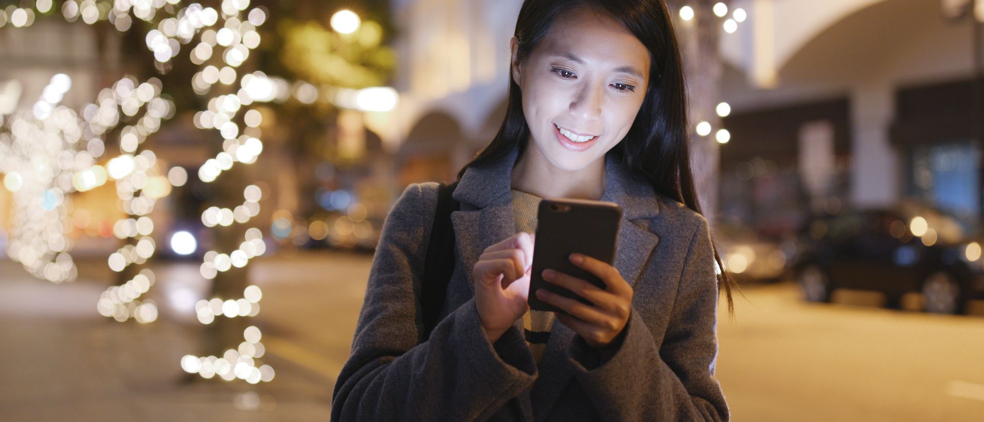 一位年轻的亚洲女性在手机上寻找SAP的工作机会