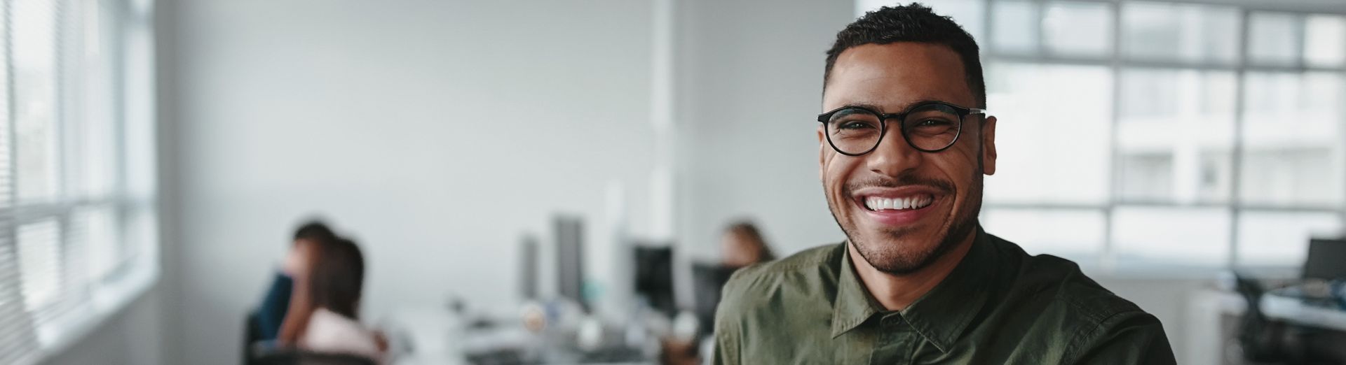 Joven empresario profesional sonriente sentado en un escritorio