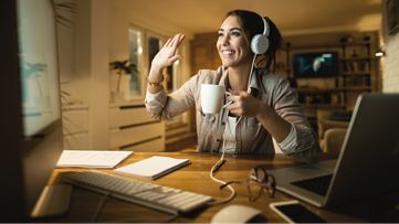 Eğitmene el sallarken rehberlere ve öğreticilere erişen bir bilgisayarın önünde bir kadın