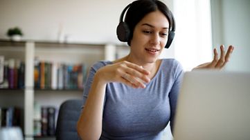 lady wearing headphones looking at laptop