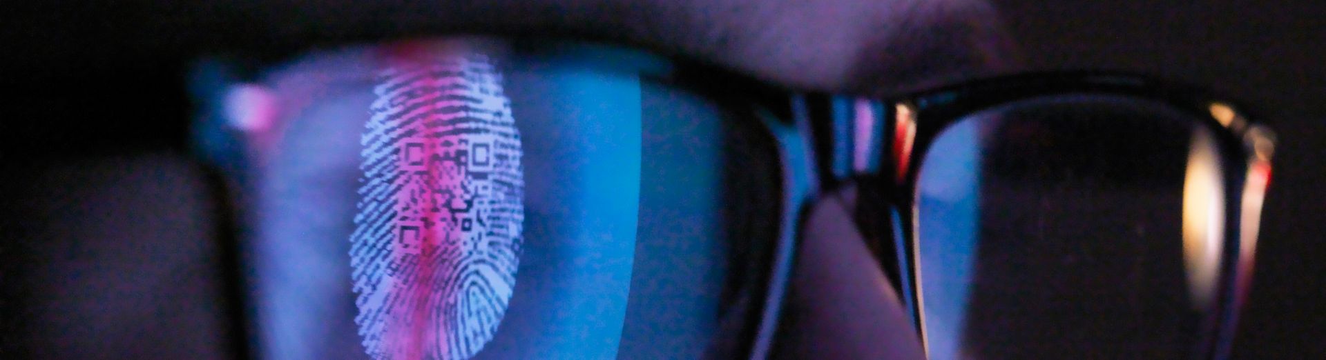 Close up of face, reflection of fingerprint in glasses