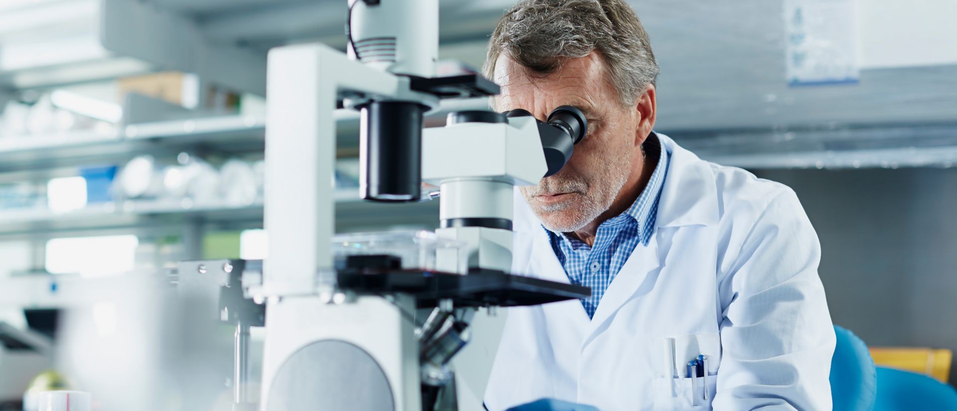 Scientist looking through microscope in research laboratory