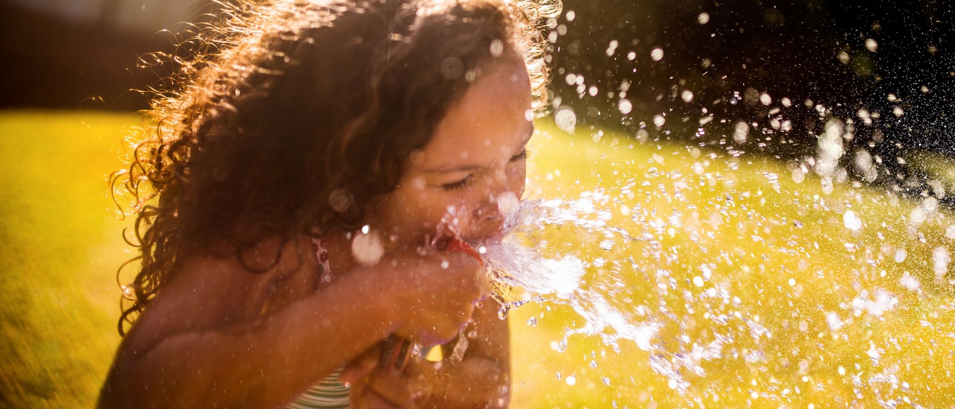 Girl drinking water from hose