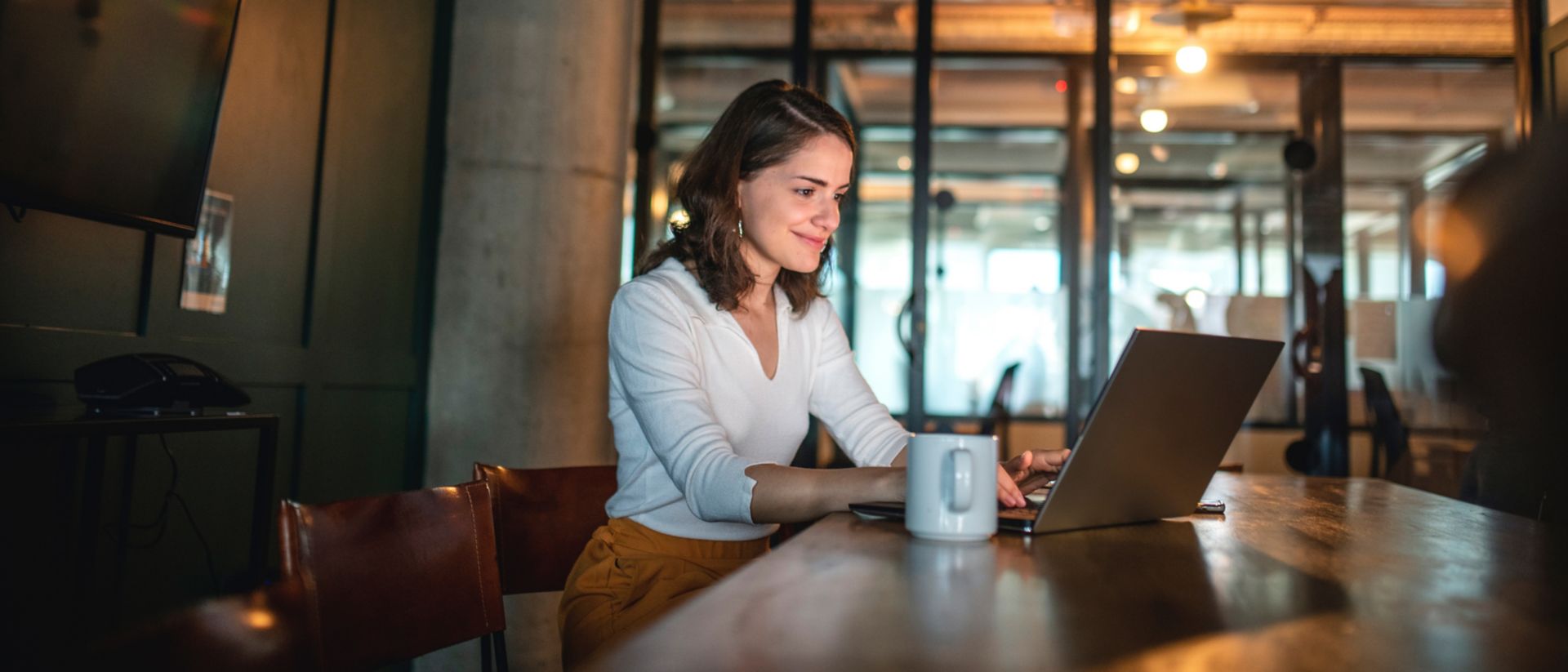 Bild einer Frau mit einem Laptop, die zum Thema Employee Experience mit HCM-Lösungen von SAP SuccessFactors recherchiert