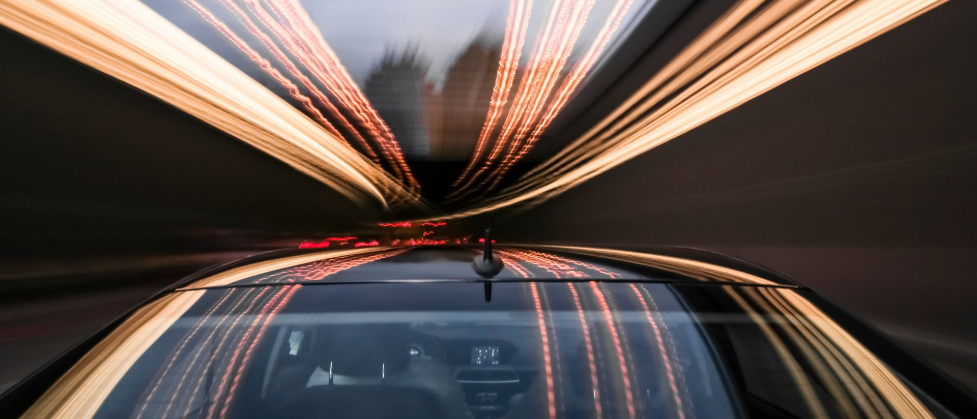 Driving black car with reflections and the rear window in foreground