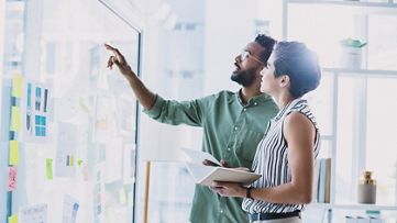 image of two people pointing to a map