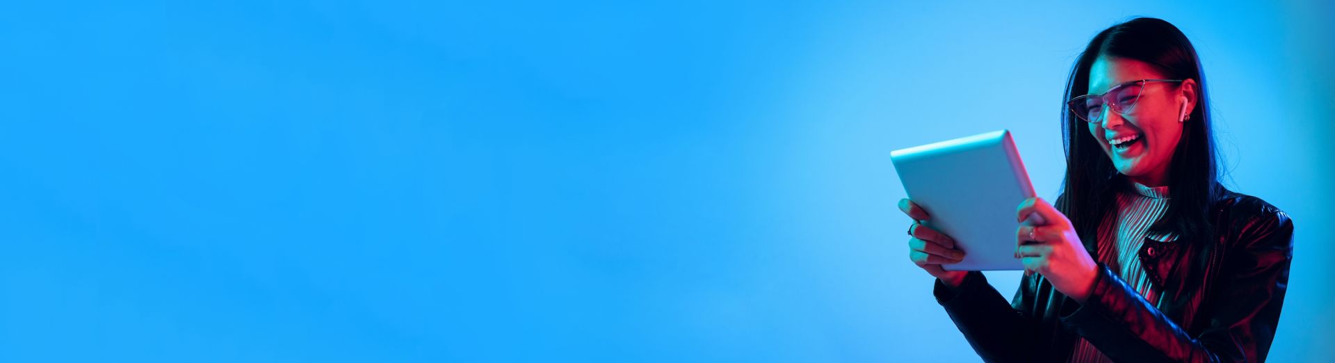 Zufriedener SAP-Cloud-ERP-Anwender, der auf einem Tablet mit blauem Hintergrund arbeitet