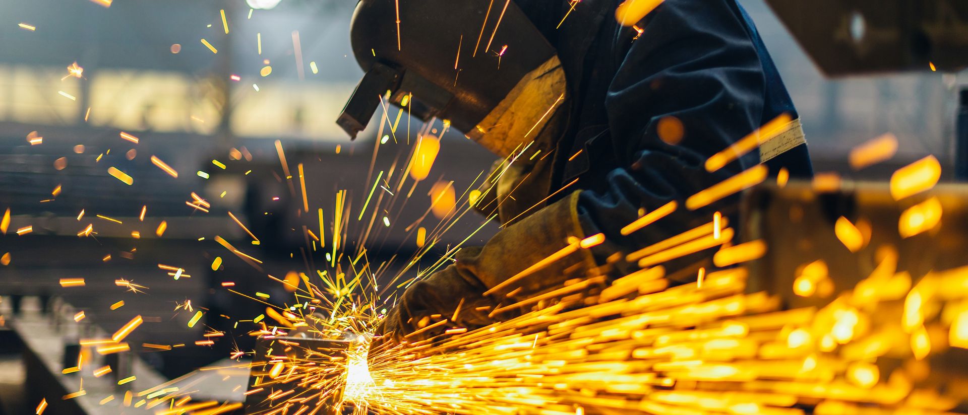 Metal worker using a grinder