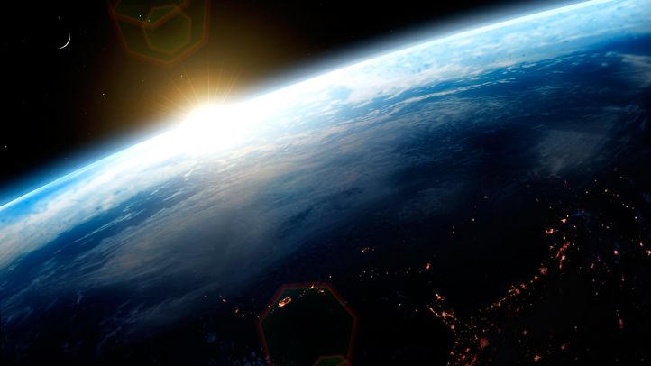 View on earth from space with sun raising on the horizon