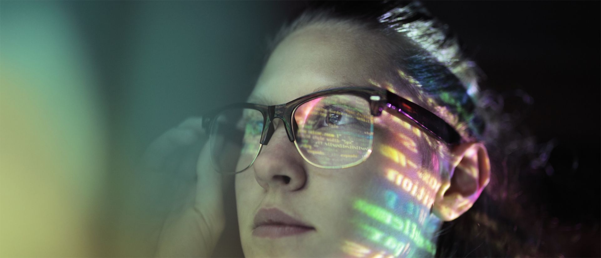 A girl’s portrait wearing glasses and light reflecting on her face