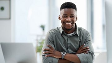 businessman smiling having laptop beside