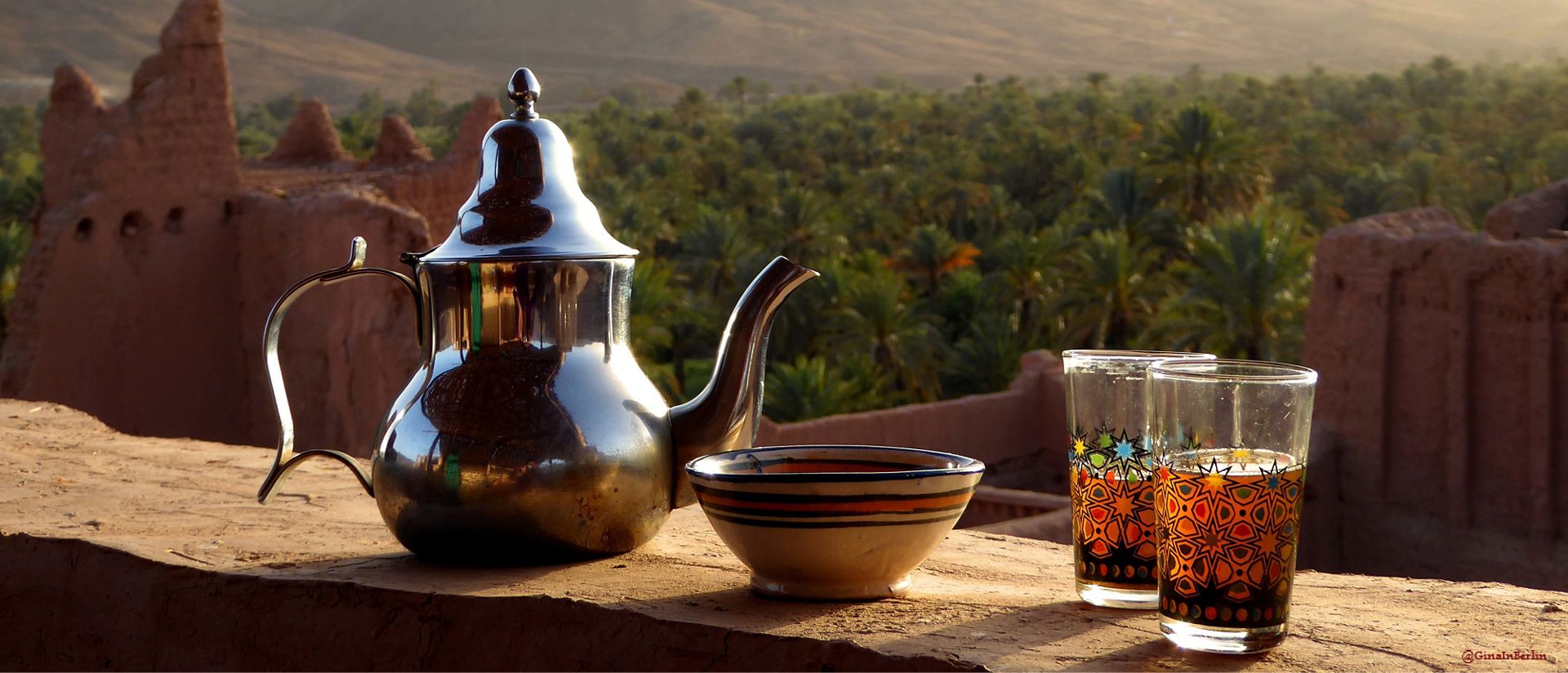 Metal teapot with drinking glasses of tea