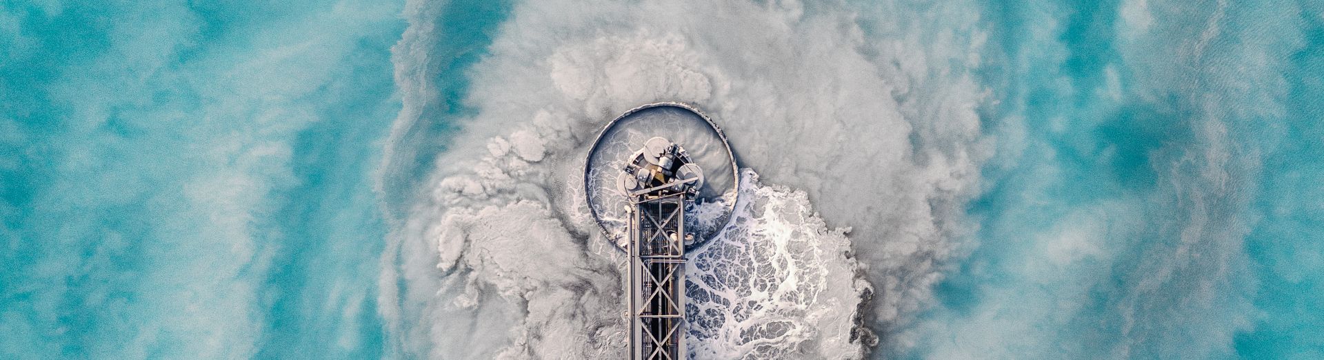 Aerial image showing swirling water patterns at a waste management facility