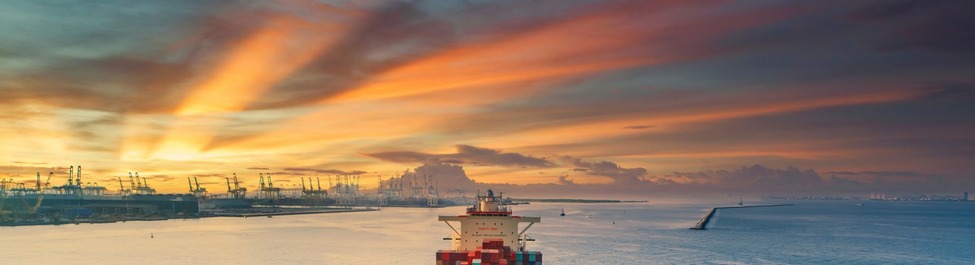 Image of a container cargo ship transporting freight  to a commercial port terminal