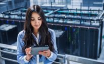  Mixed race businesswoman using digital tablet on balcony over server room