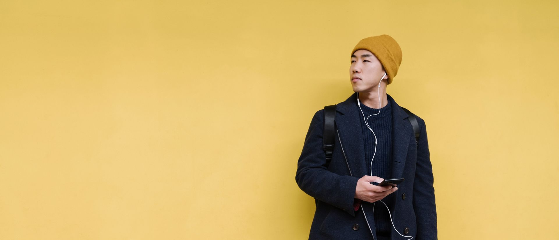 Jeune homme devant un mur jaune