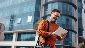 En mand, der går og bruger en tablet