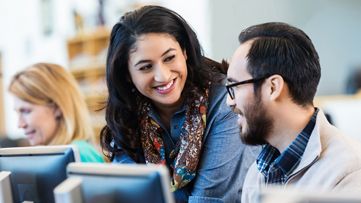 2 people at a computer smiling