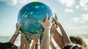 People holding their hands on a globe ball