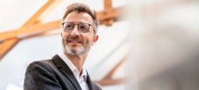 オフィスで目をそらしながら微笑むビジネスマンのポートレート