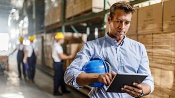 A man working with a tablet in a warehouse