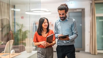 オフィスでタブレットを確認する女性と男性