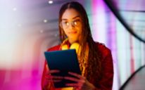 Jeune femme avec des lunettes utilisant une tablette dans un tunnel souterrain éclairé