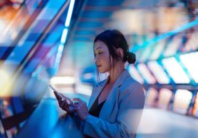woman looking at a tablet with futuristic background
