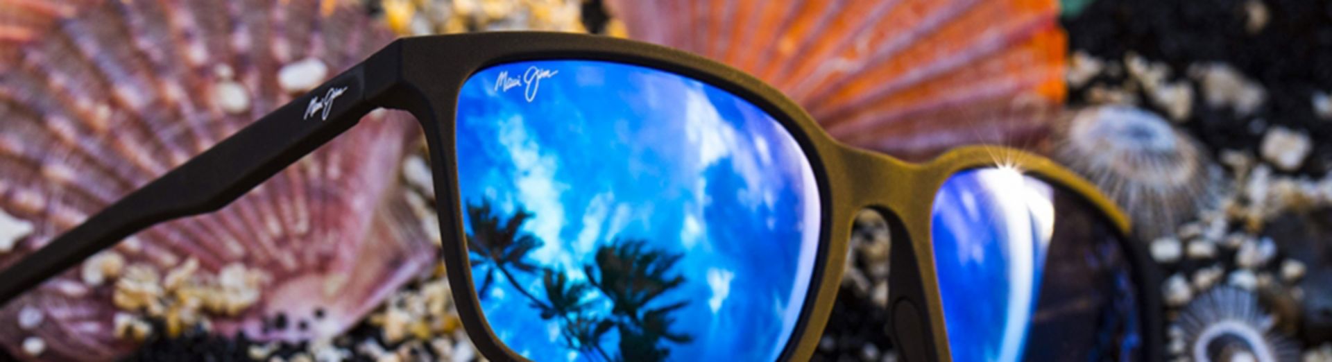 Sonnenbrille von Maui Jim in der sich Palmen spiegeln