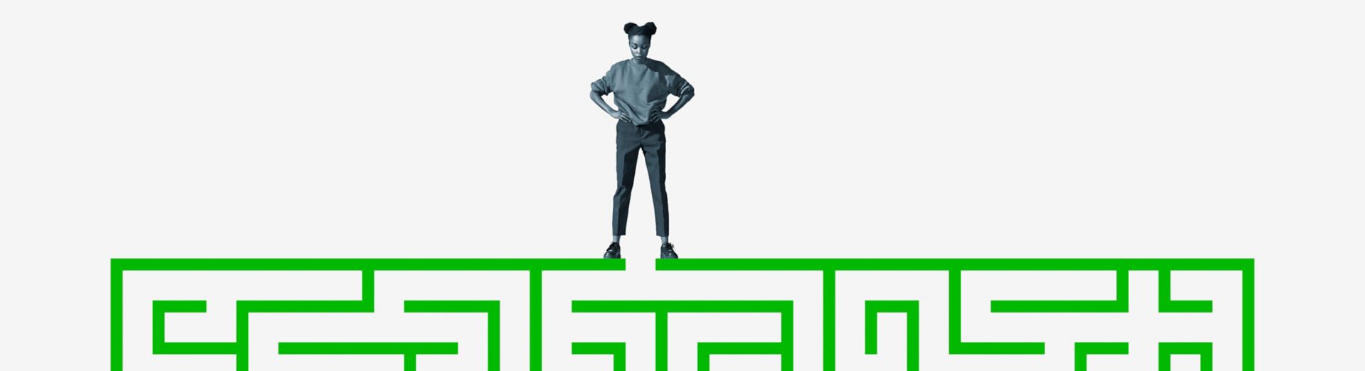 Woman stands on top of a green maze.